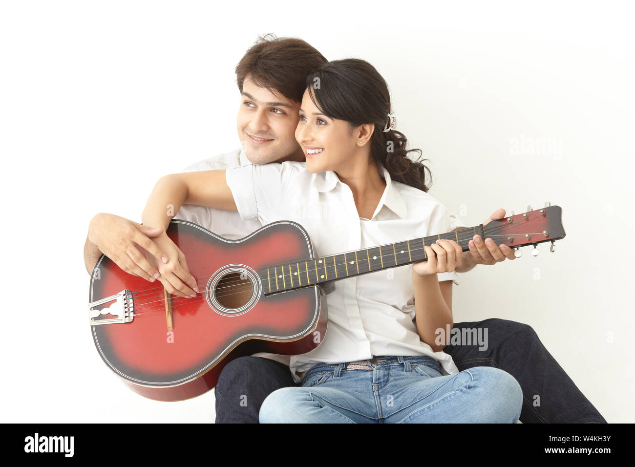 Man teaching woman to play guitar Stock Photo