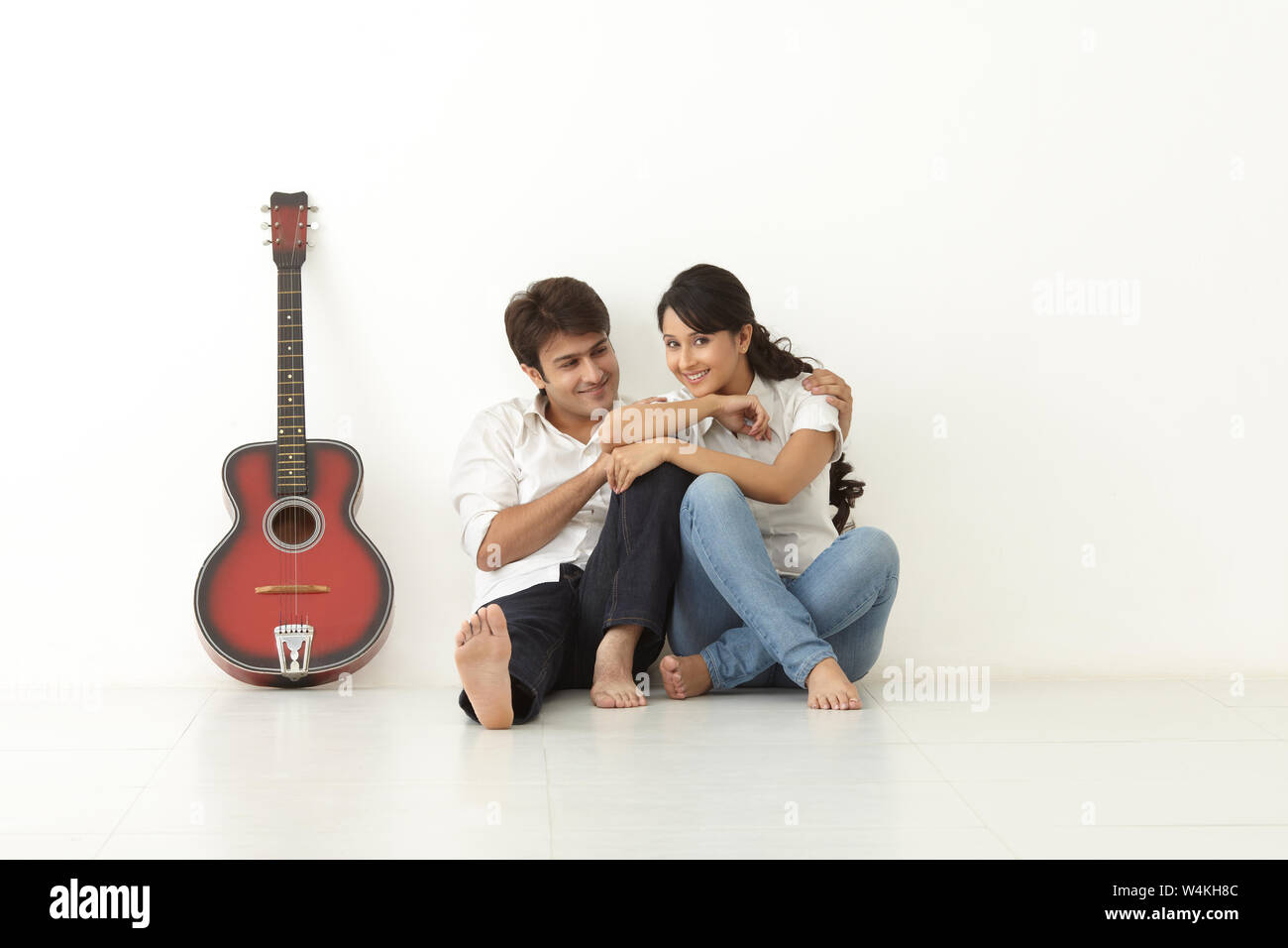 Indian couple sitting on floor and smiling Stock Photo - Alamy