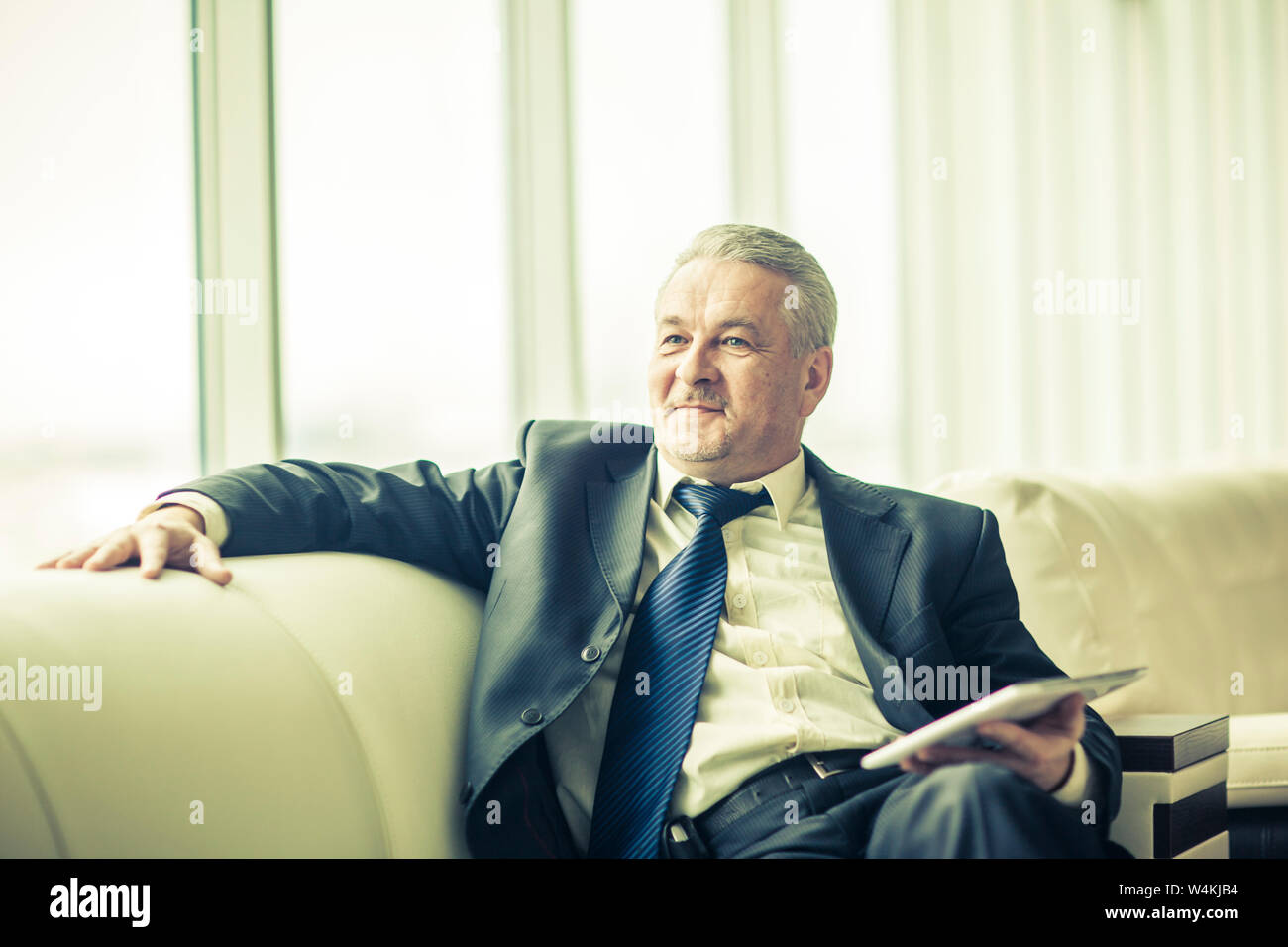 lawyer with digital tablet sitting on the sofa in the private office. the photo has a empty space for your text Stock Photo