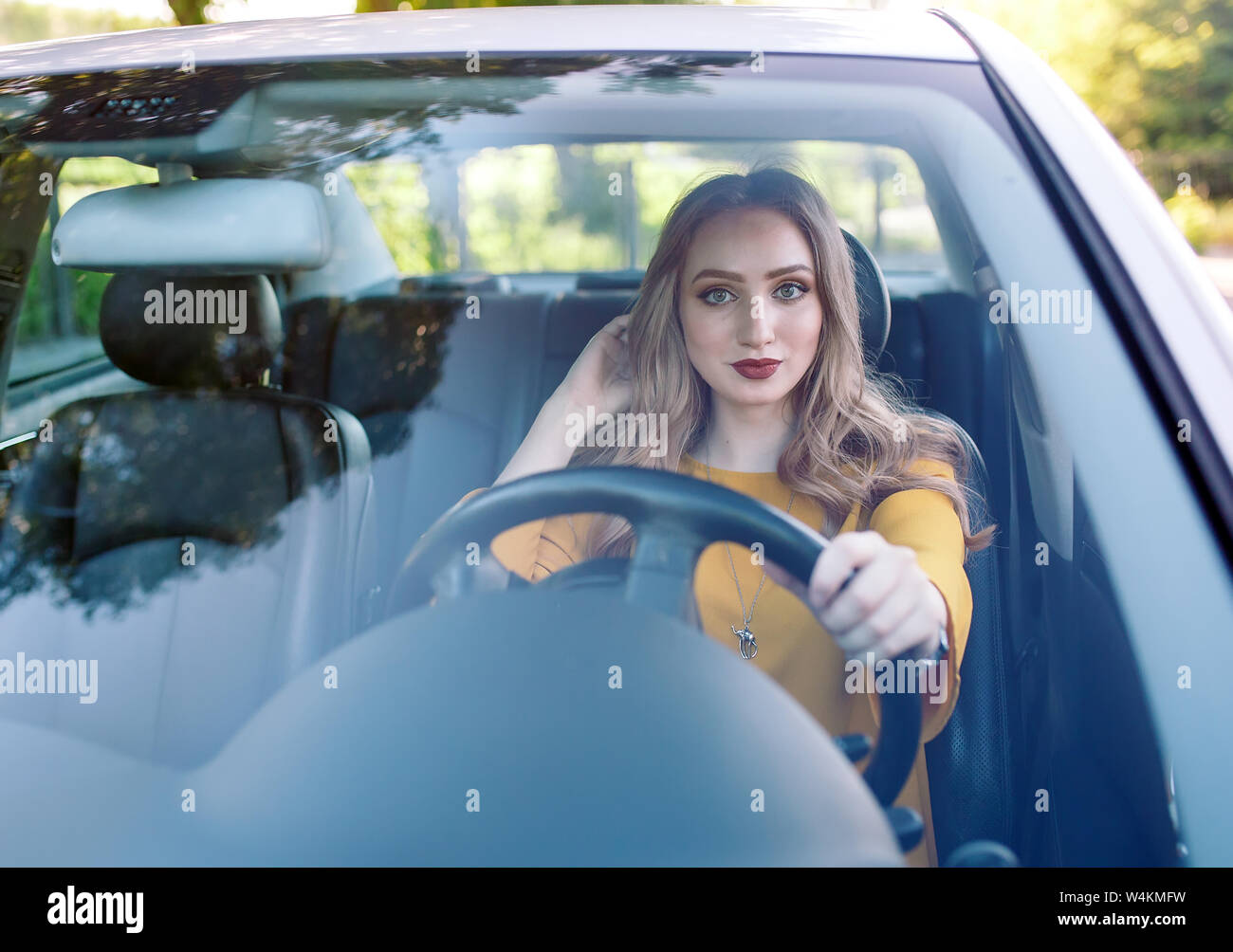 A young beautiful girl is driving a car Stock Photo Alamy
