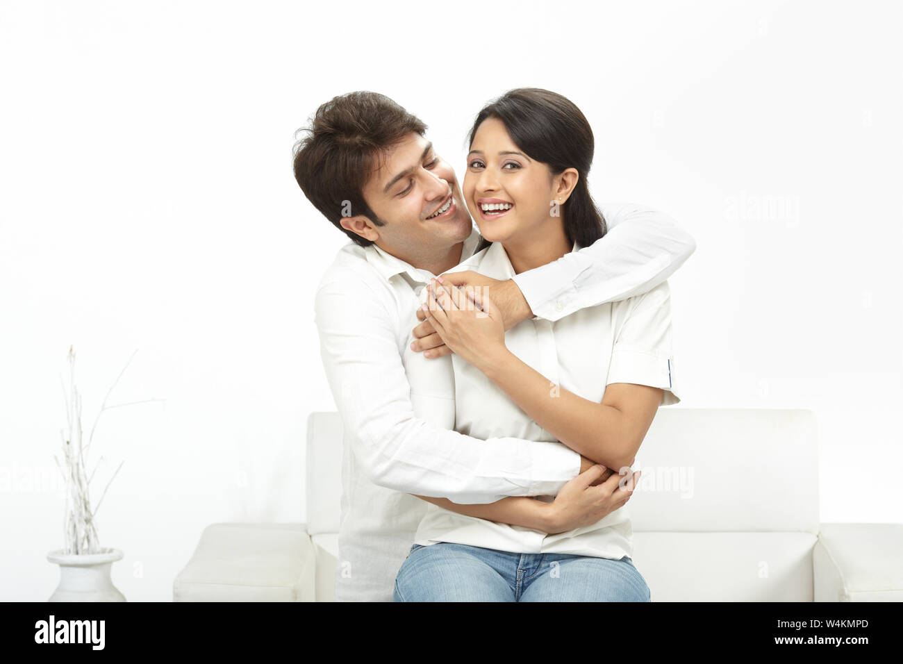 Young man embracing a woman from behind and smiling Stock Photo - Alamy