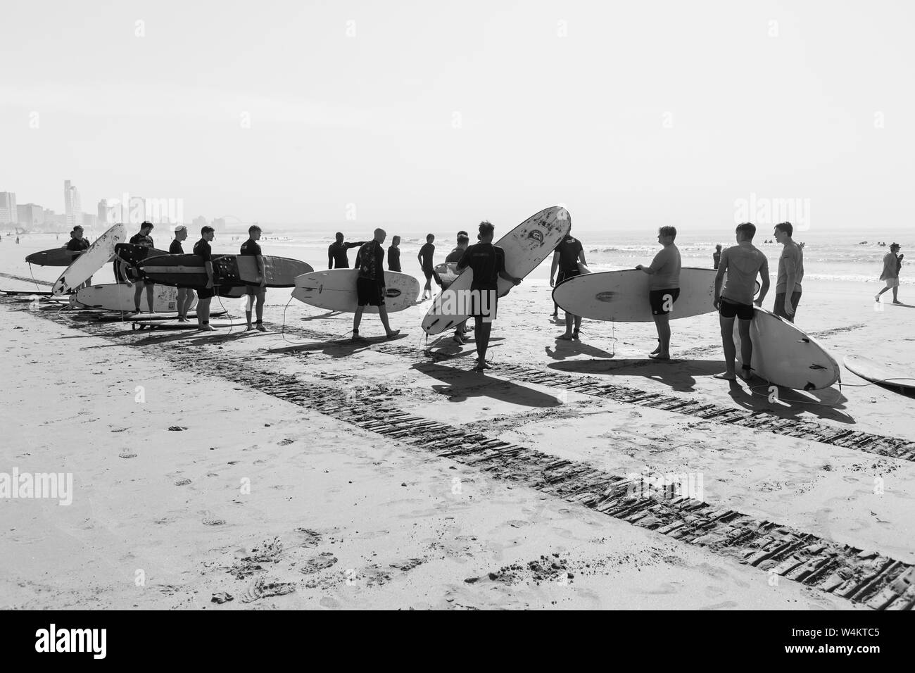 Surfing lessons on beach with surfboards with young men and surfer