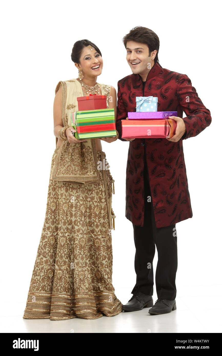 Newlywed couple holding gift boxes and smiling Stock Photo