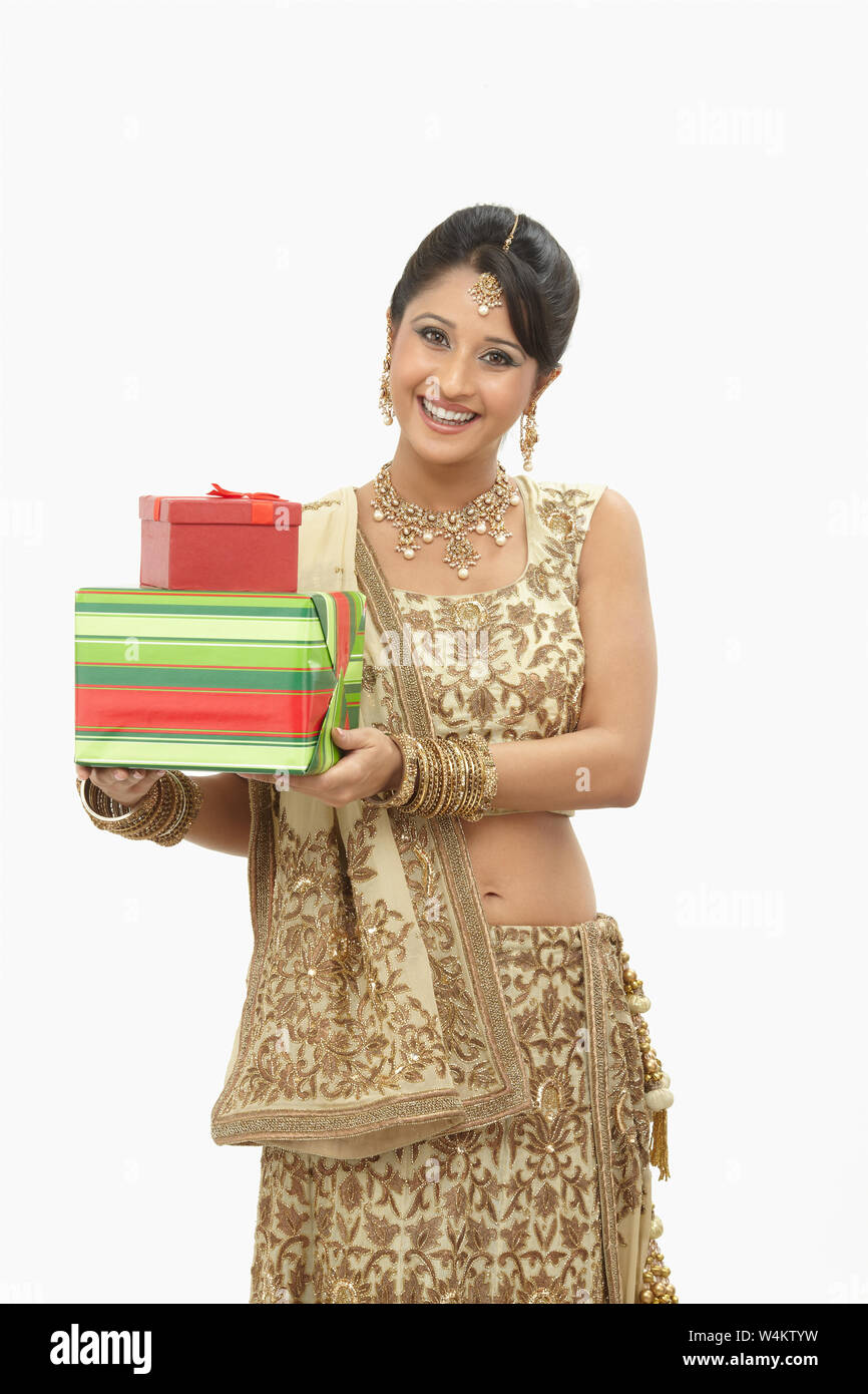 Indian bride holding gift boxes and smiling Stock Photo