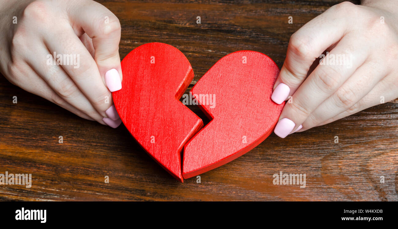 A woman collects a broken heart in his hands. Concept of love and ...