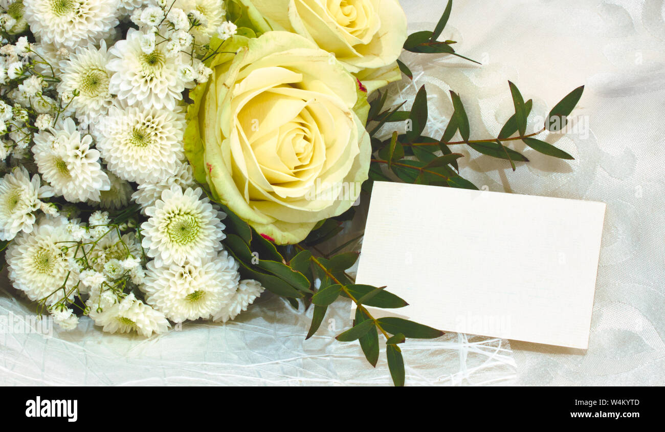 Bouquet of white and yellow flowers with an empty greeting card Stock Photo