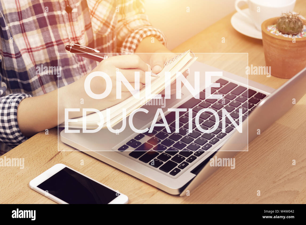 online learning course concept. student using computer laptop for training online and writing lecture note in notebook with text online education on t Stock Photo