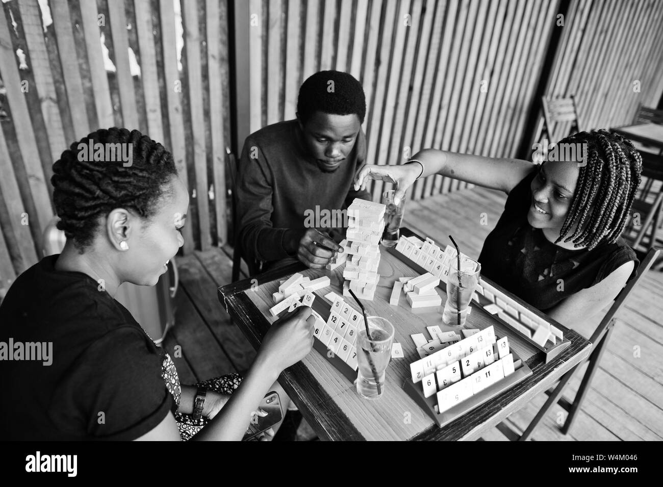 Group of three african american friends play table games Stock Photo Alamy
