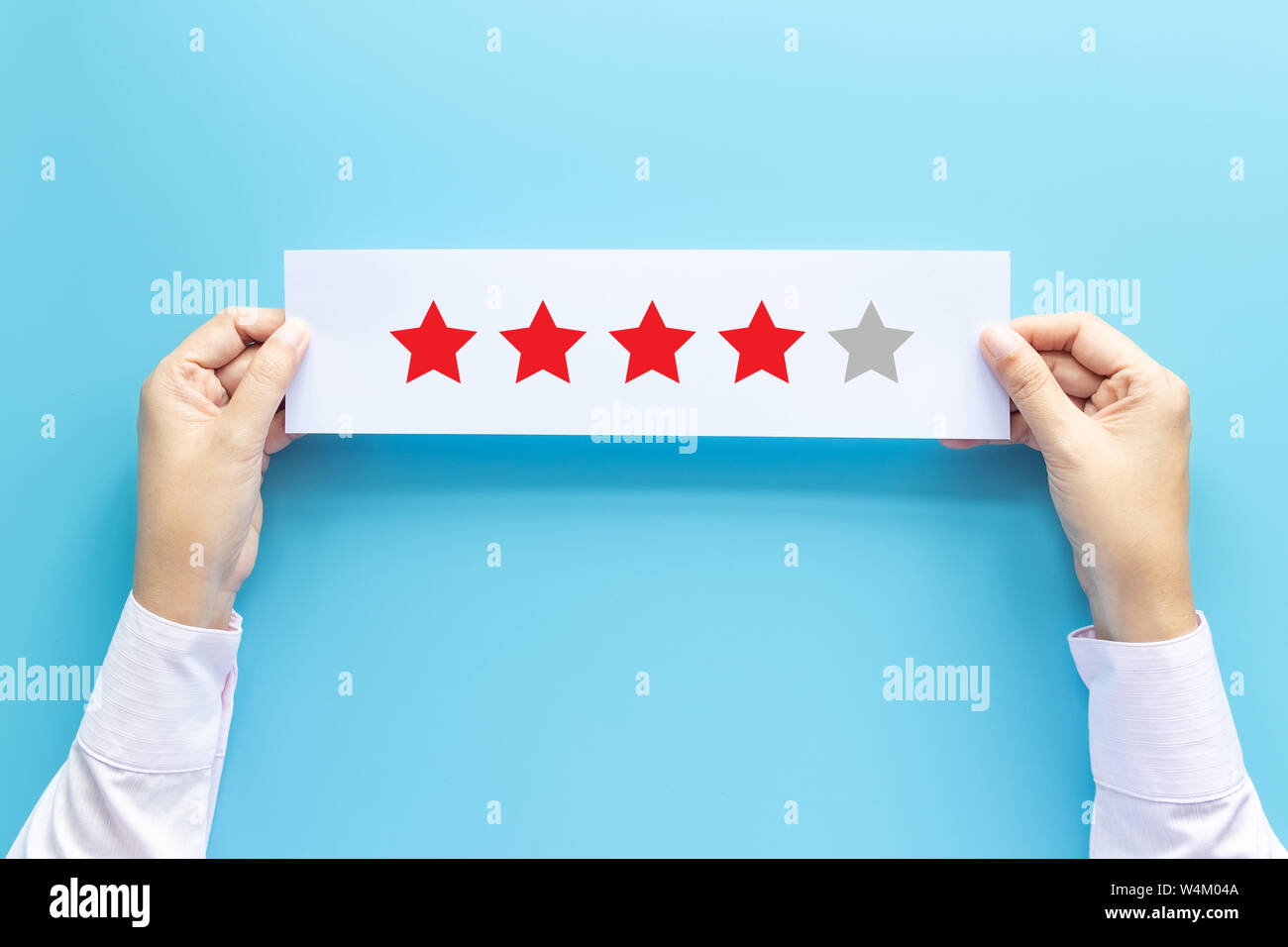 rating and feedback concept. customer holding paper with satisfied review by give star for service experience Stock Photo