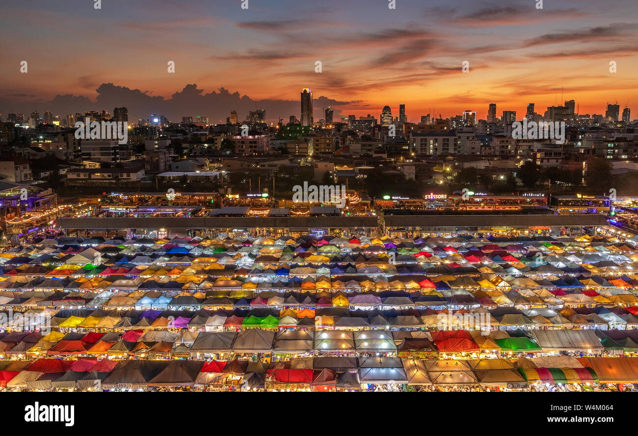 top view of busy Asian street food at railway night market in Thailand with colorful stall and light at night time Stock Photo