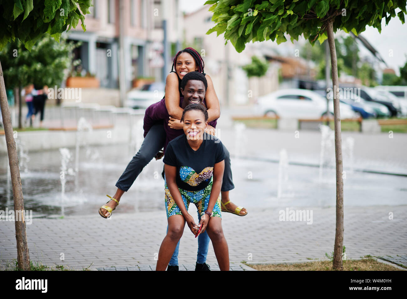 Three african american friends having fun together. Jump on shoulder ...