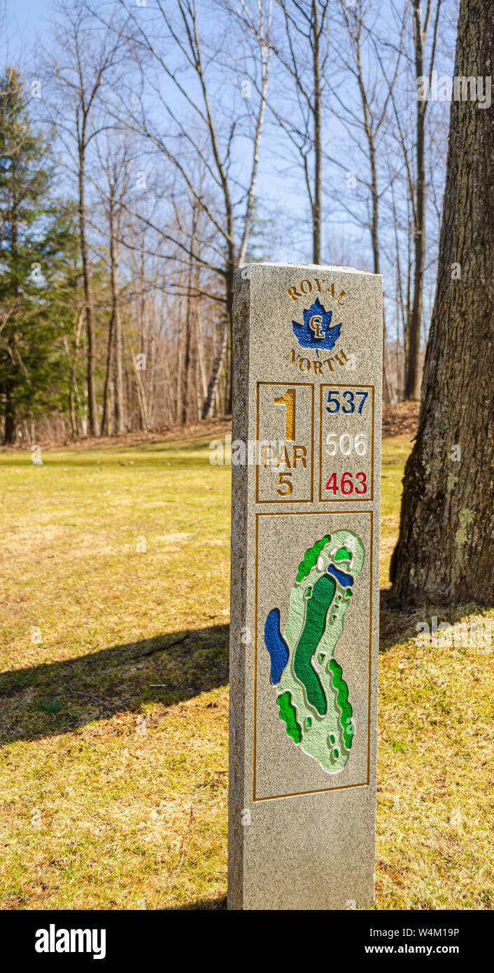 A granite totem tee sign on a golf course. Hole 1 Par 5. 463 yard red tee marker; 506 yard white tee marker; 537 yard blue tee marker. Stock Photo