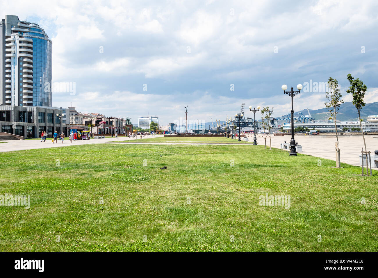 NOVOROSSIYSK, RUSSIA - JULY 7, 2019: people walk near lawns on Admiral Serebryakov Embankment in Novorossiysk. Novorossiysk is city in Krasnodar Krai, Stock Photo