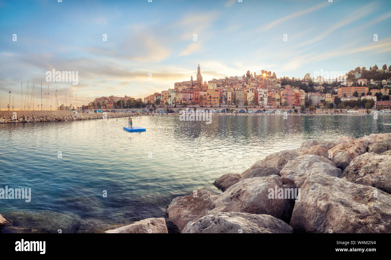 Public beach of Menton old town at sunset Stock Photo