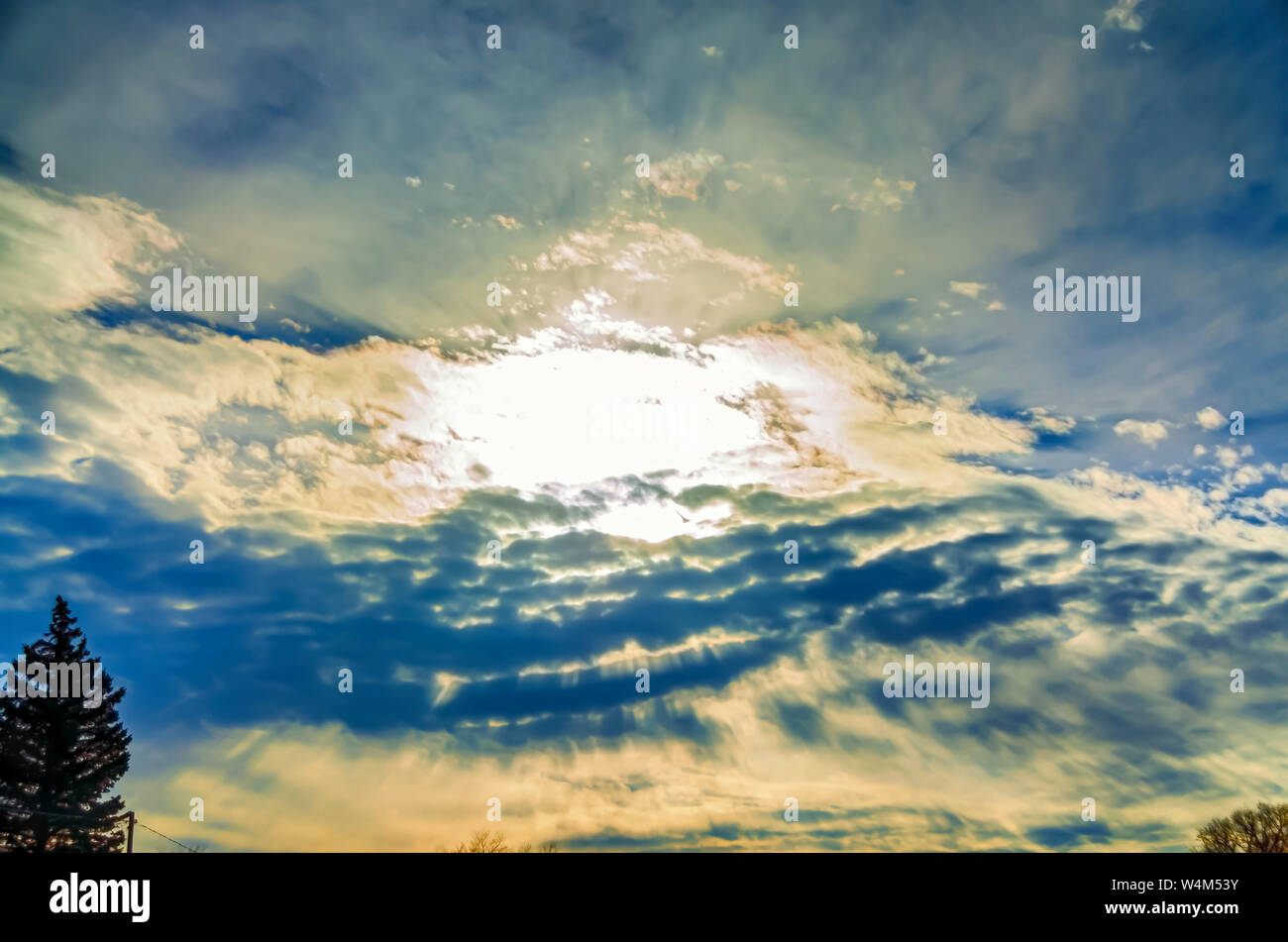 The song and dance between the sun and the clouds to create a dramatic evening sky. Stock Photo