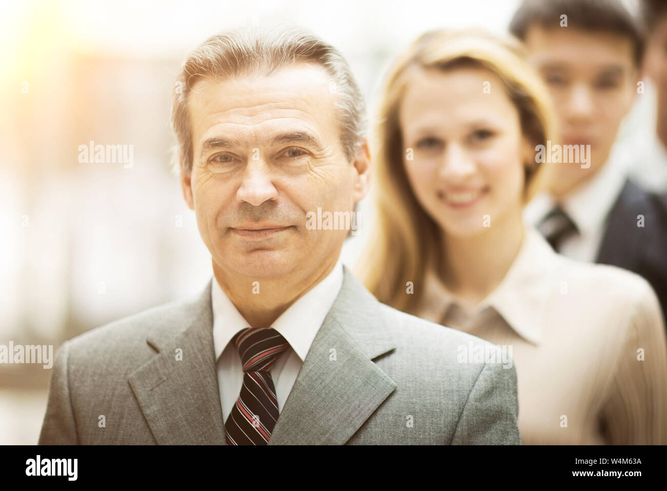 Happy smiling business team standing in a row at office Stock Photo - Alamy