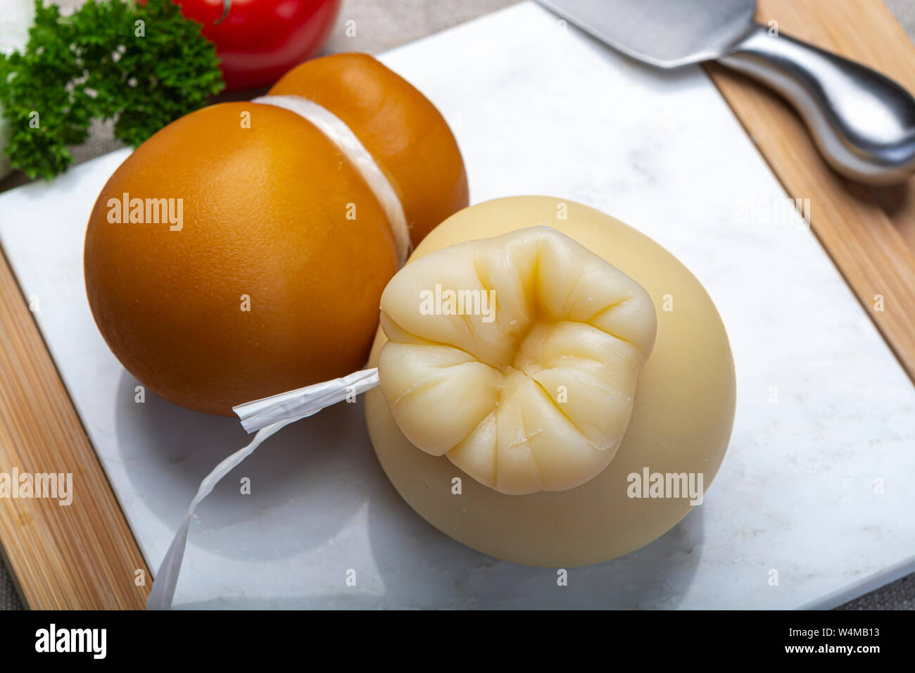 Cheese collection, Italian provolone or provola caciocavallo hard and smoked cheeses in teardrop form served on white marble plate close up Stock Photo