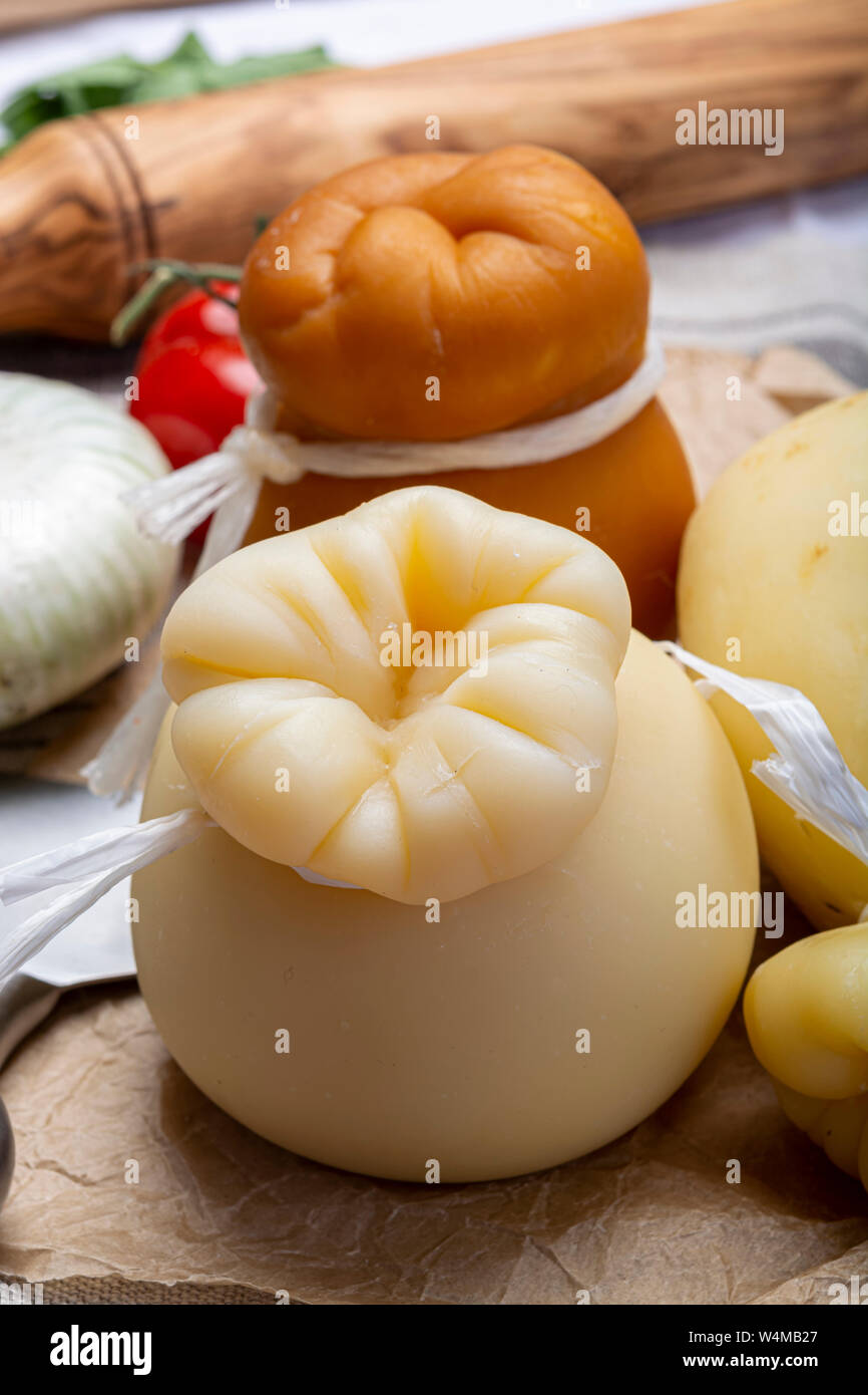 Cheese collection, Italian provolone or provola caciocavallo hard and smoked cheeses in teardrop form served on old paper close up Stock Photo