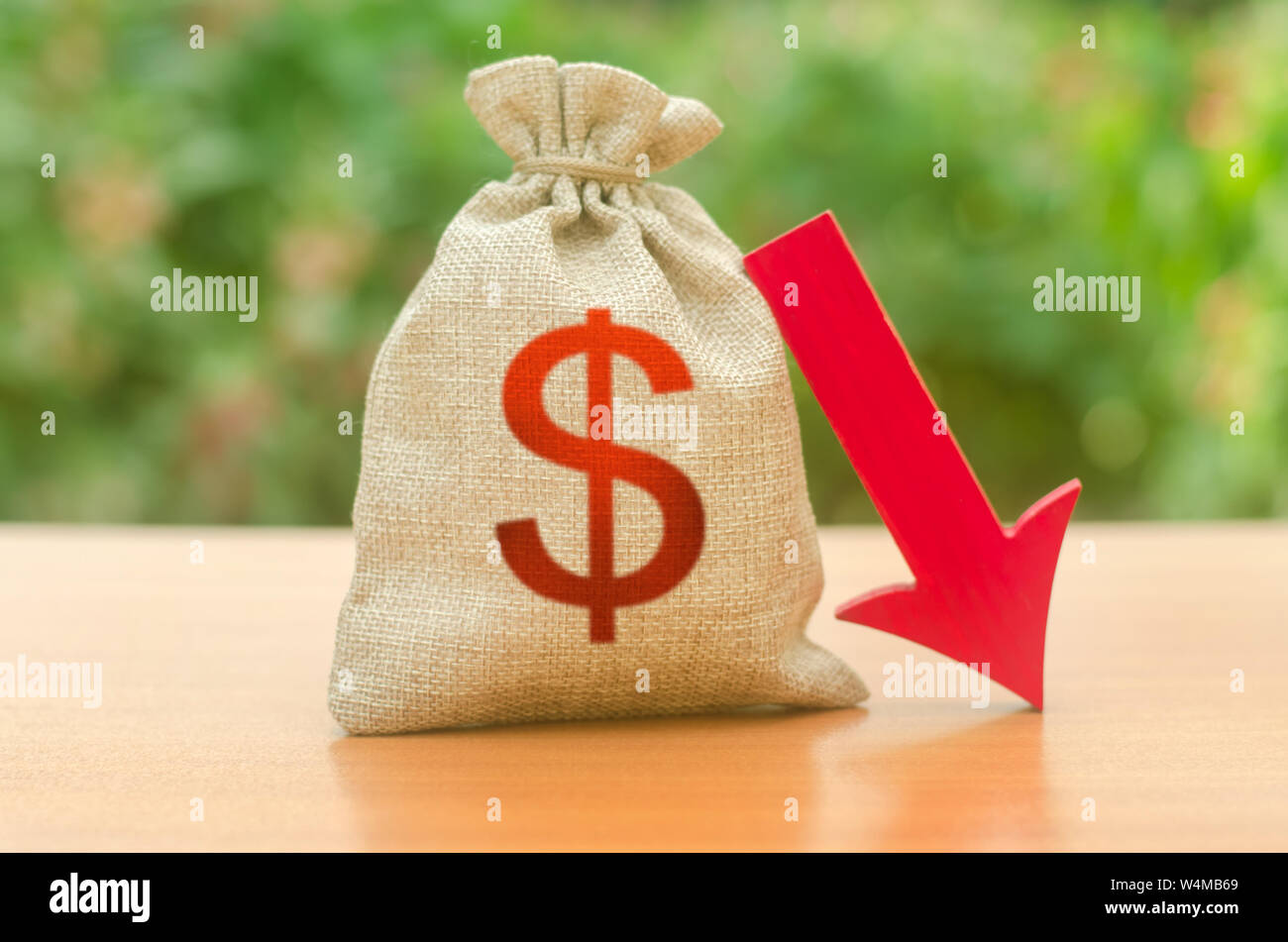 Money bag with dollar symbol and red arrow down. Reduced tax revenues, economic difficulties, departure of capital, investors. Falling wages and welfa Stock Photo