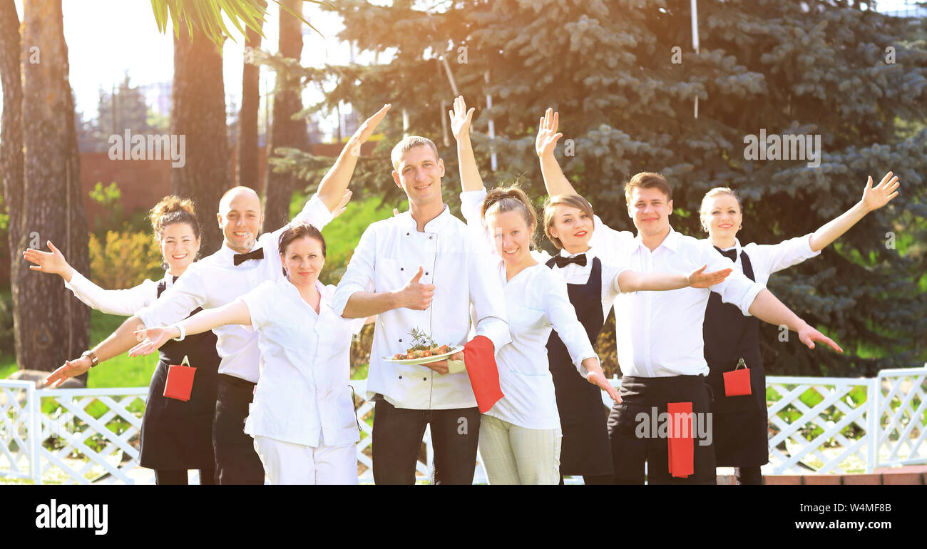 A large group of happy and emotional waiters standing in a row behind