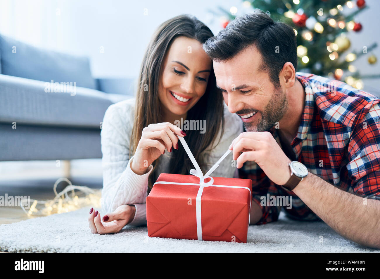 Happy couple opening a Christmas present Stock Photo