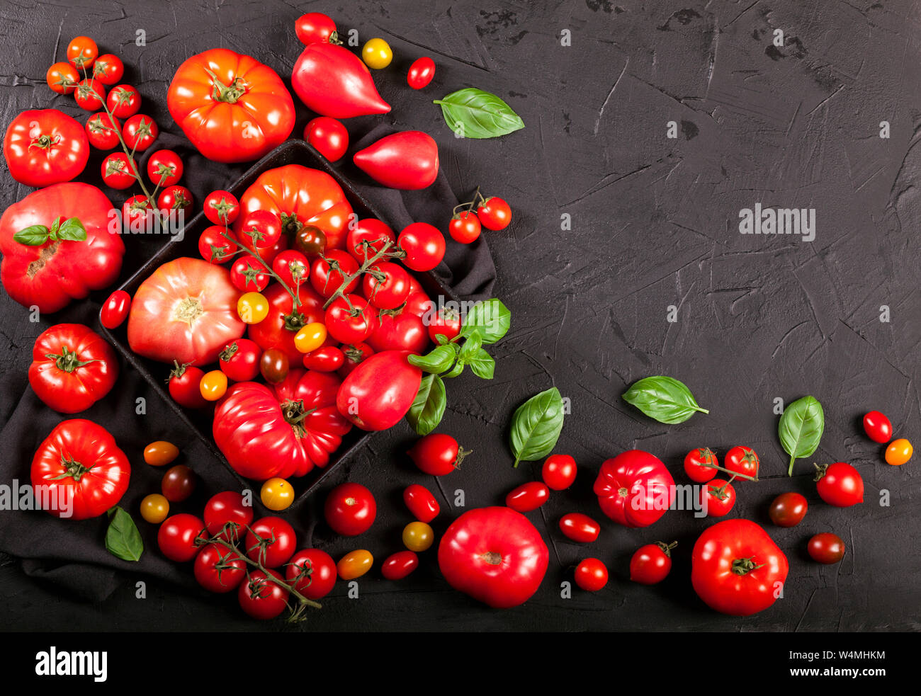 Tomatoes on a black background top view copy space Stock Photo - Alamy