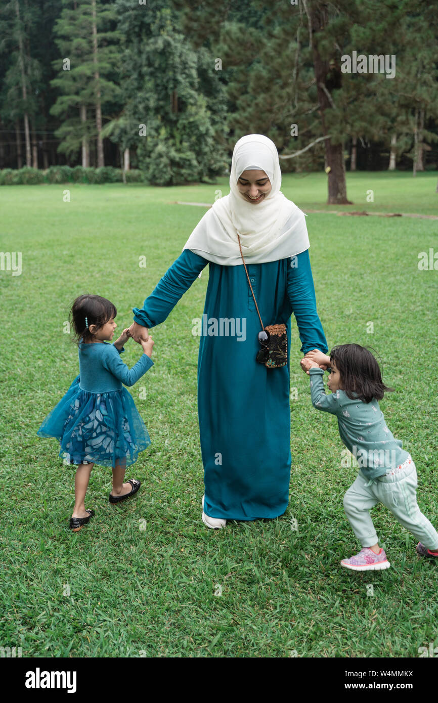 Muslim mother plays with her two children Stock Photo - Alamy