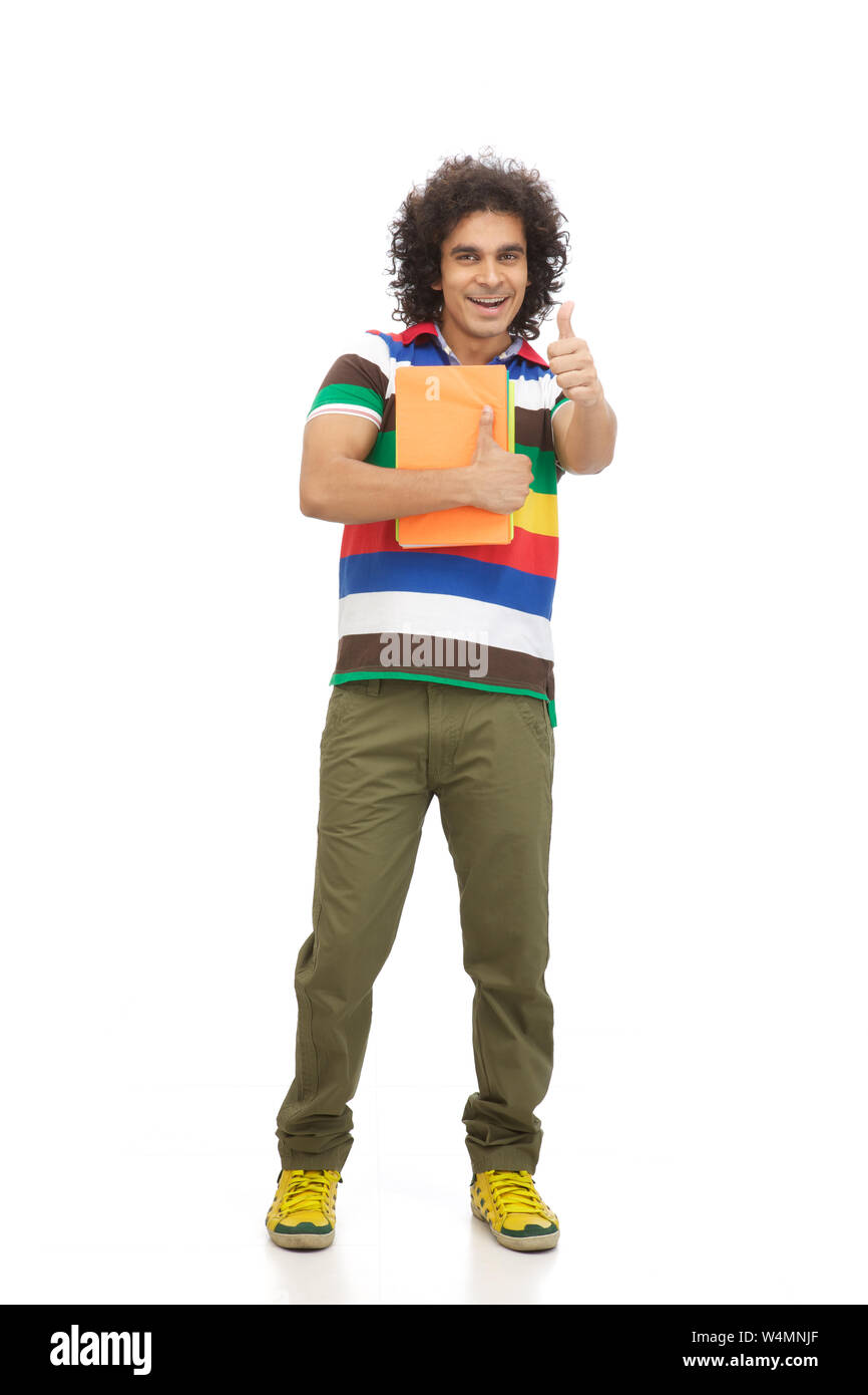 College student showing thumbs up sign and smiling Stock Photo - Alamy