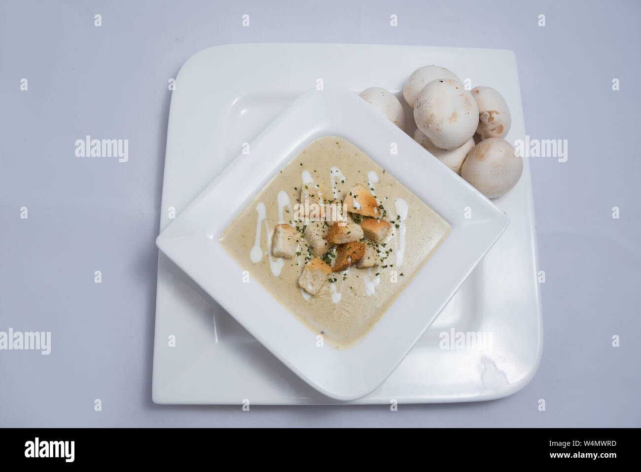 Hero Shot of a Mushroom Soup with bread crumbs, oregano on a minimal