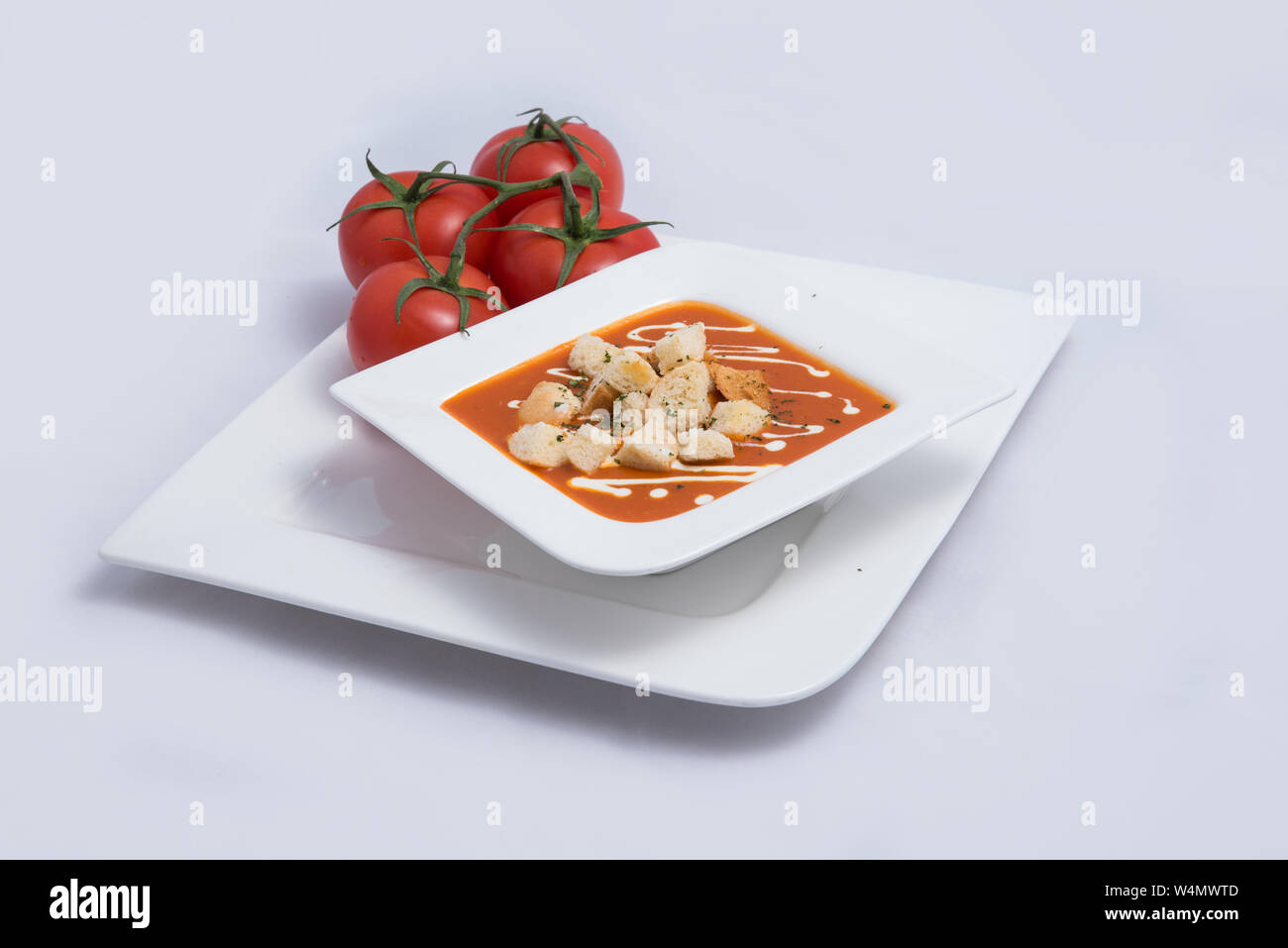 a Hero Shot of a Tomato Soup with bread crumbs, oregano on a minimal