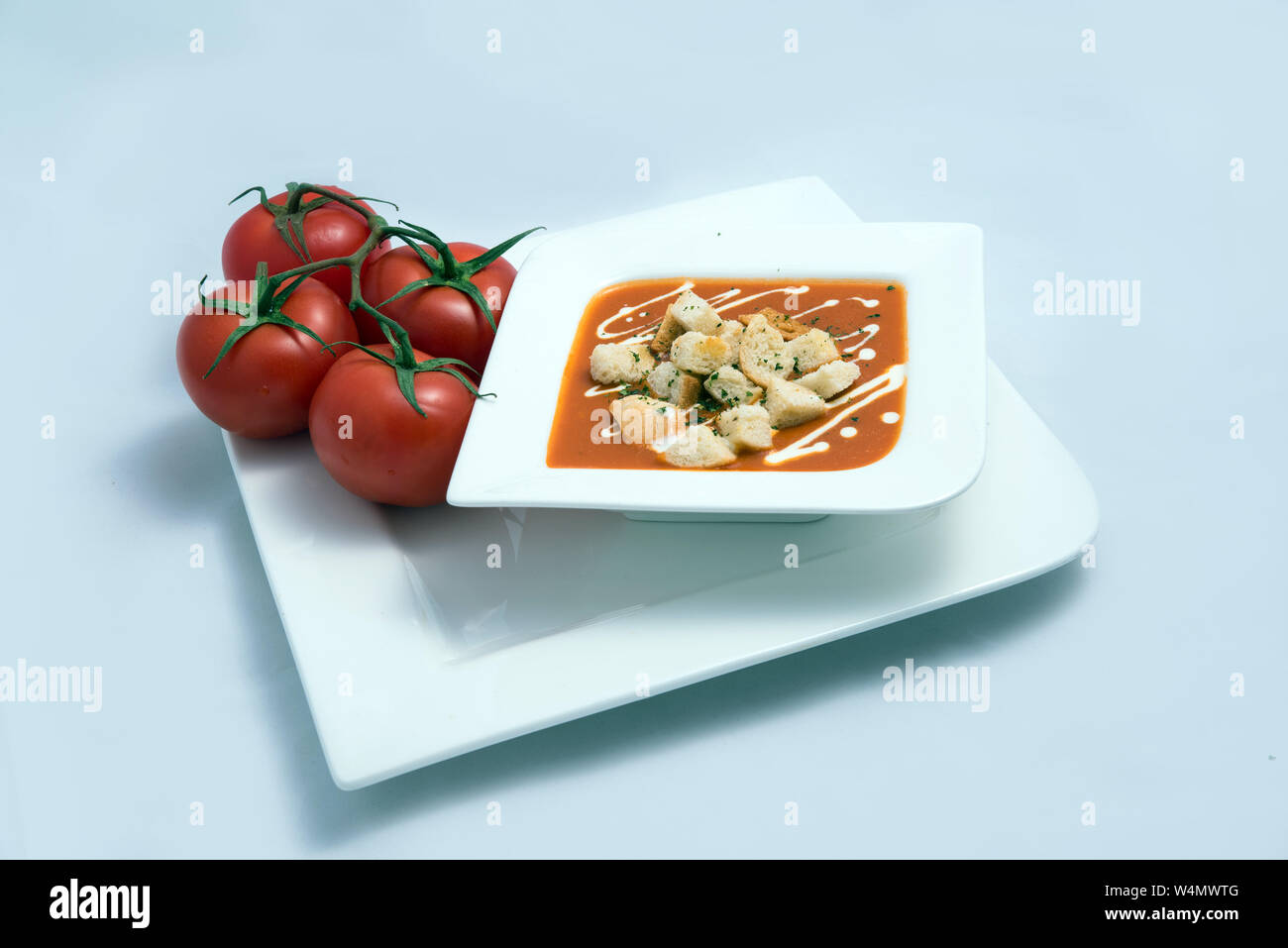 a Hero Shot of a Tomato Soup with bread crumbs, oregano on a minimal