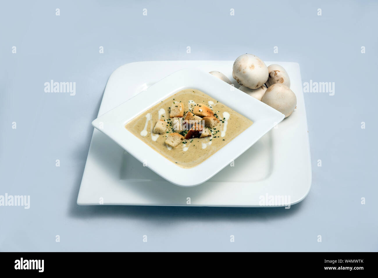 Contrasted Hero Shot of a Mushroom Soup with bread crumbs, oregano on a