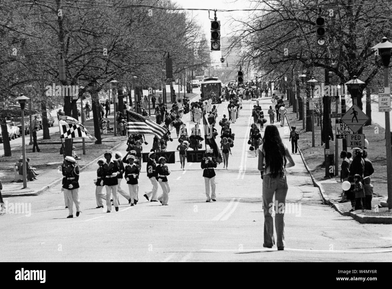 Parade with marching band and cheerleaders walking in formation along North Charles Street, holding flags and banners, during 3400 On Stage Festival at Johns Hopkins University, Baltimore, Maryland, April, 1978. From the Historical Photographs Collection. () Stock Photo
