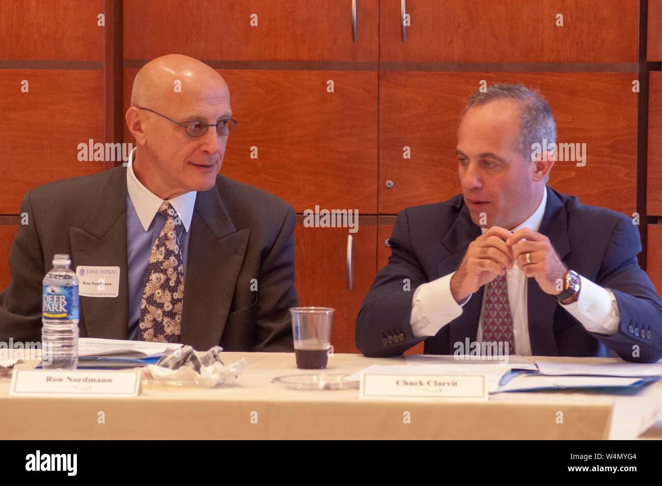 Business leader Ron Nordmann (left) and finance professional Chuck Clarvit (right) converse as they sit together behind a table during a leadership event at the Johns Hopkins University in Baltimore, Maryland, June 7, 2004. From the Homewood Photography collection. () Stock Photo