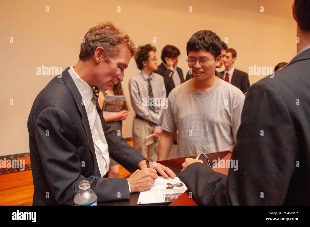 Profile shot of science communicator Bill Nye, signing his autograph for a fan, during a Milton S Eisenhower Symposium at the Johns Hopkins University, Baltimore, Maryland, October 23, 2007. From the Homewood Photography Collection. () Stock Photo