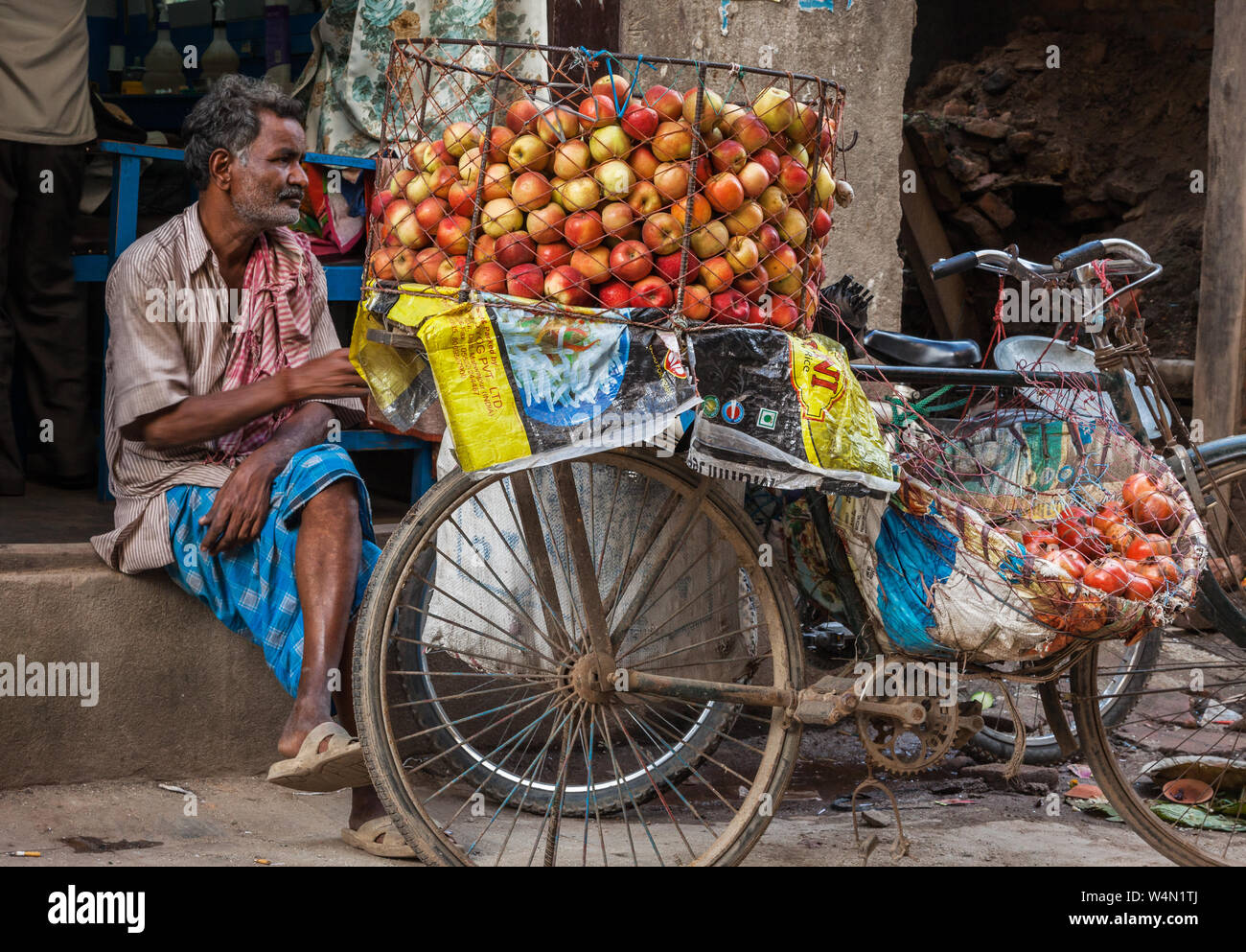 Man selling apples from his bicycle on a street in Kathmandu Stock Photo