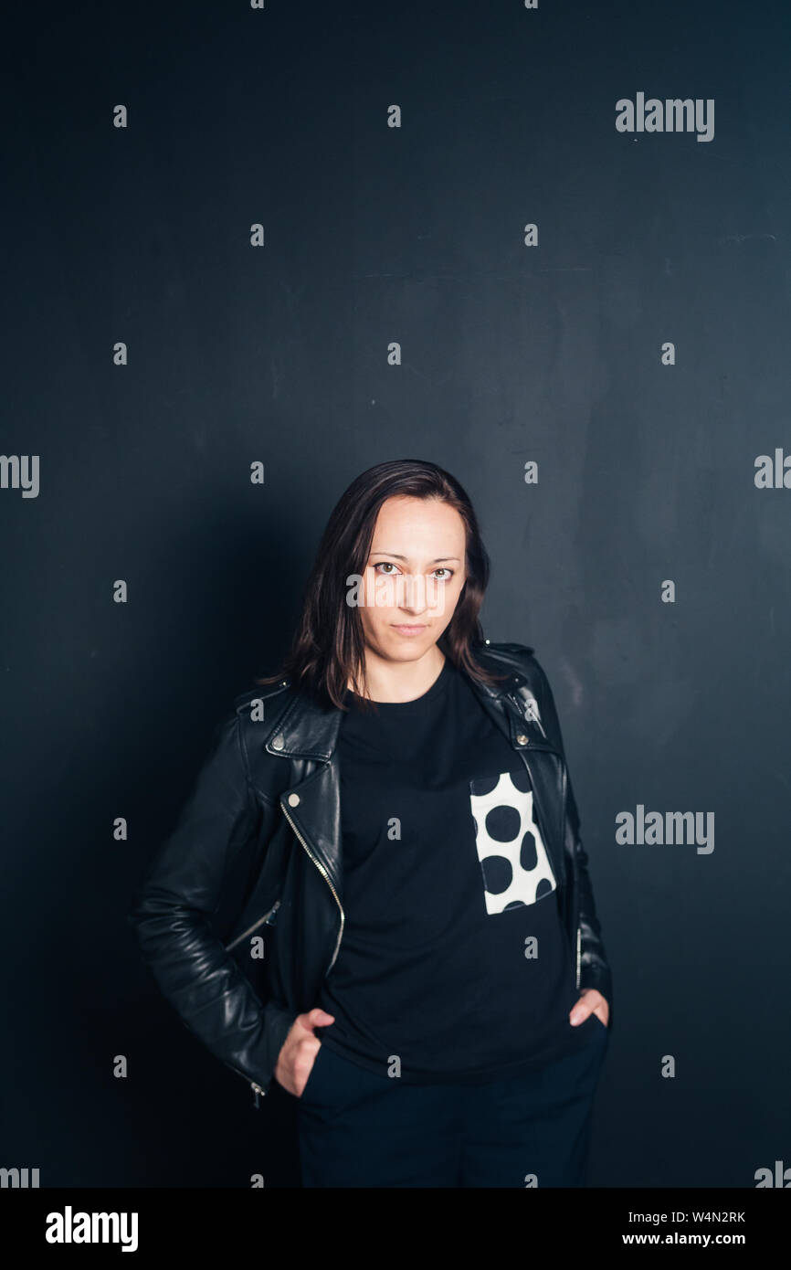 Studio portrait of an attractive young woman in a black leather jacket ...