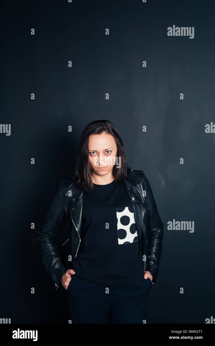 Studio portrait of an attractive young woman in a black leather jacket ...