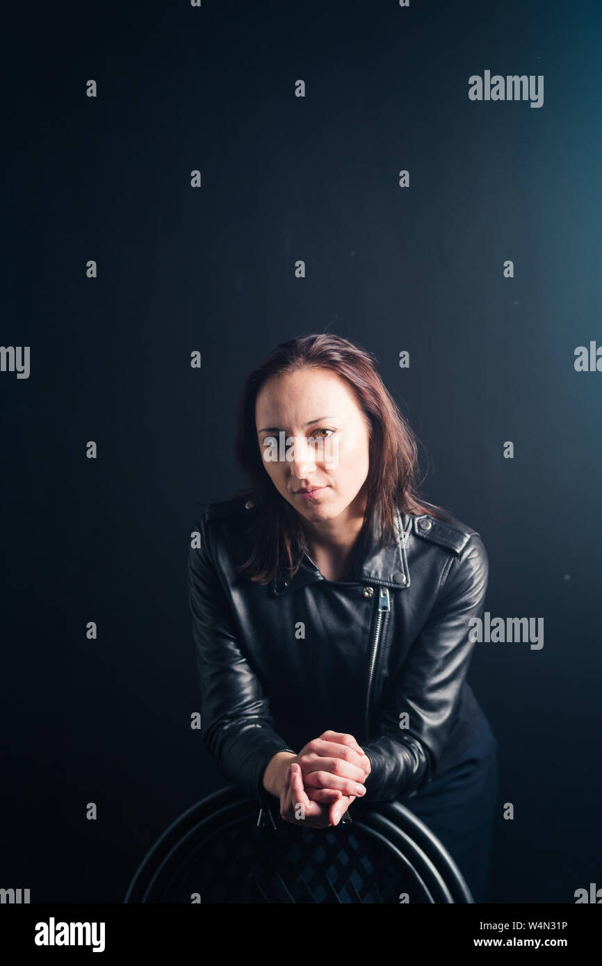 Studio portrait of an attractive young woman in a black leather jacket ...