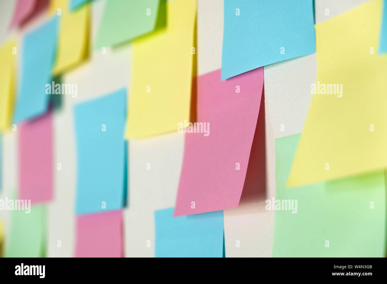 Sticky paper notes on a planning board, close-up view. Planning, brainstorm, diversity or fresh ideas concept - pattern of empty multicolored paper no Stock Photo