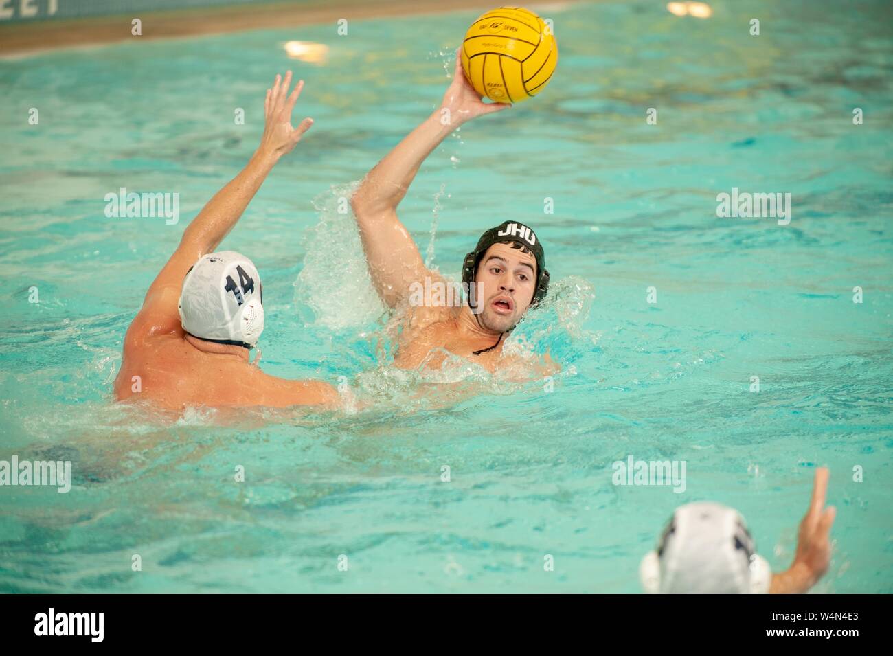 A Johns Hopkins Blue Jays Men's Water Polo player holds the ball in one hand while participating in a game with Bucknell University, October 16, 2009. From the Homewood Photography Collection. () Stock Photo