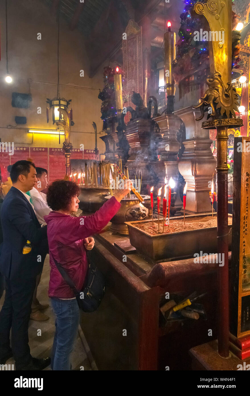 Worshippers in Man Mo Temple, a Taoist temple on Hollywood Road, Sheung Wan, Central district, Hong Kong Island, Hong Kong, China Stock Photo