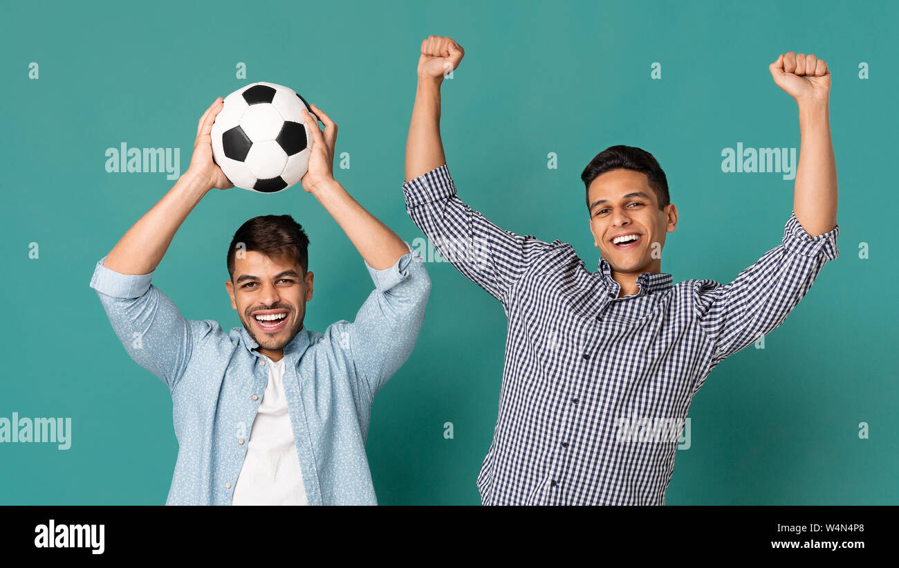 Two Soccer Fans Holding Ball And Celebrating Victory Stock Photo