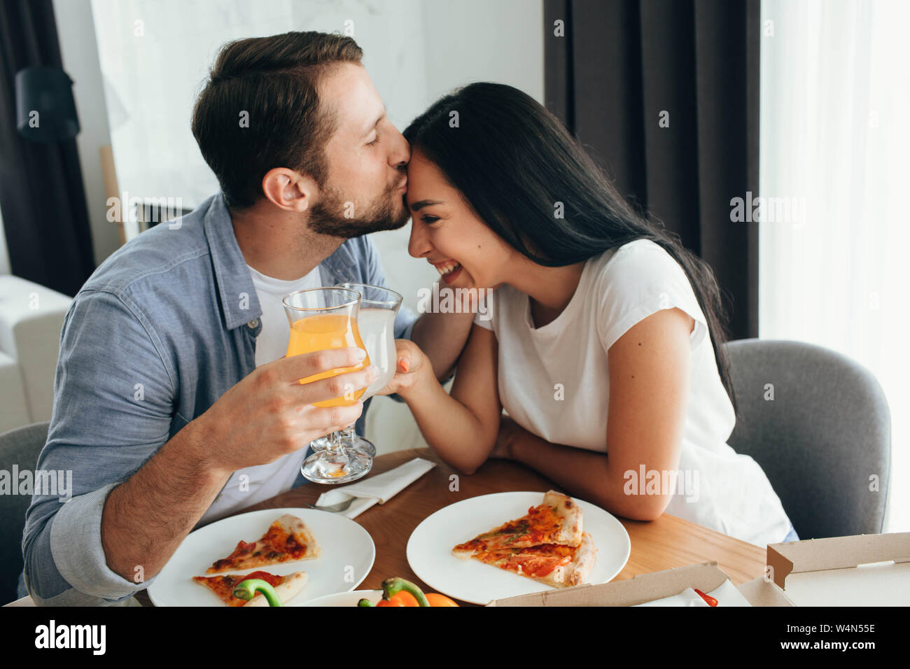 Happy couple kissing and have dinner with pizza at home. Its a good time  spending home Stock Photo - Alamy