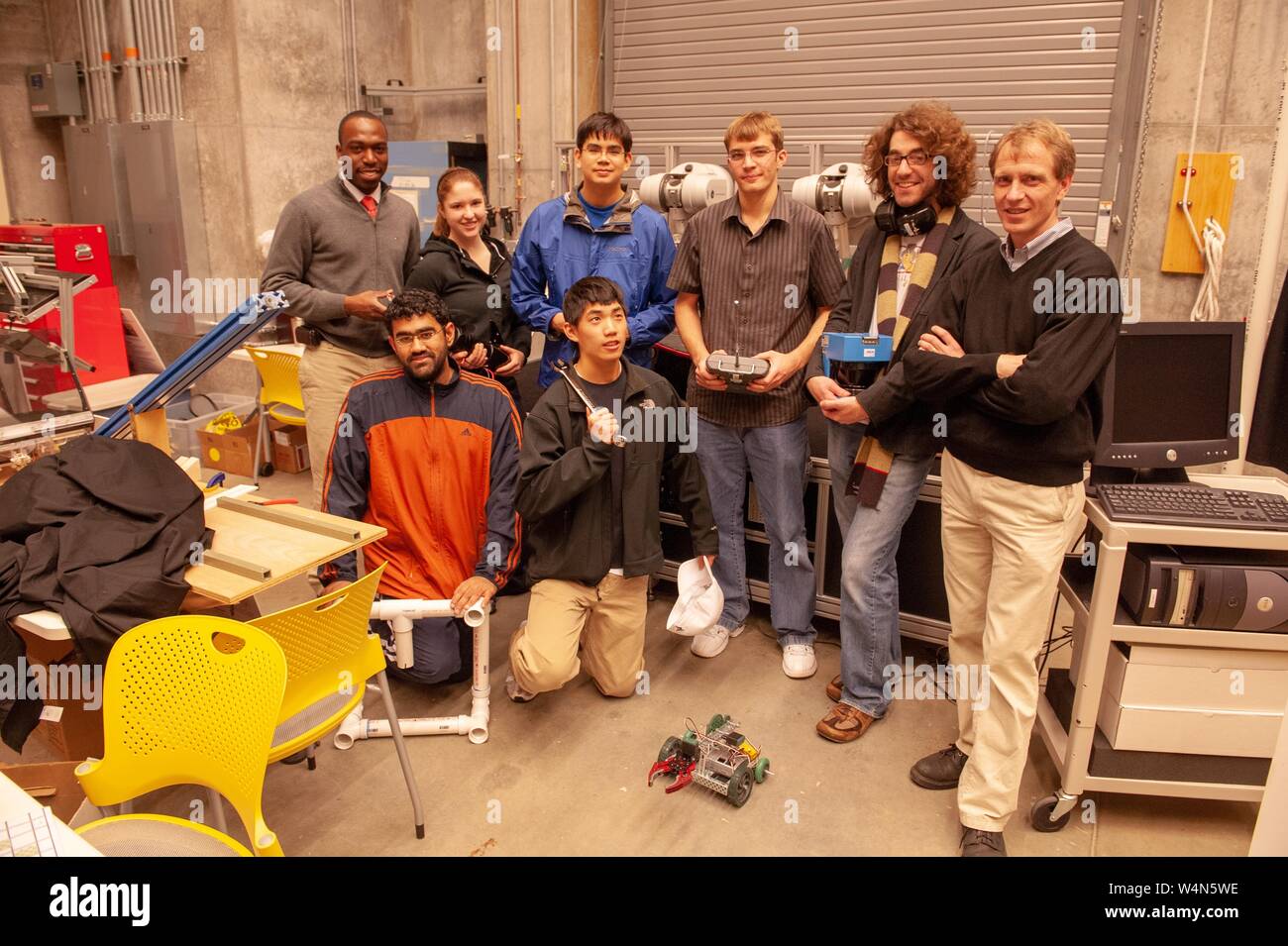 Members of the Johns Hopkins Robotics Club, pose together with a remote controlled robot, at the Johns Hopkins University, Baltimore, Maryland, December, 2009. From the Homewood Photography Collection. () Stock Photo