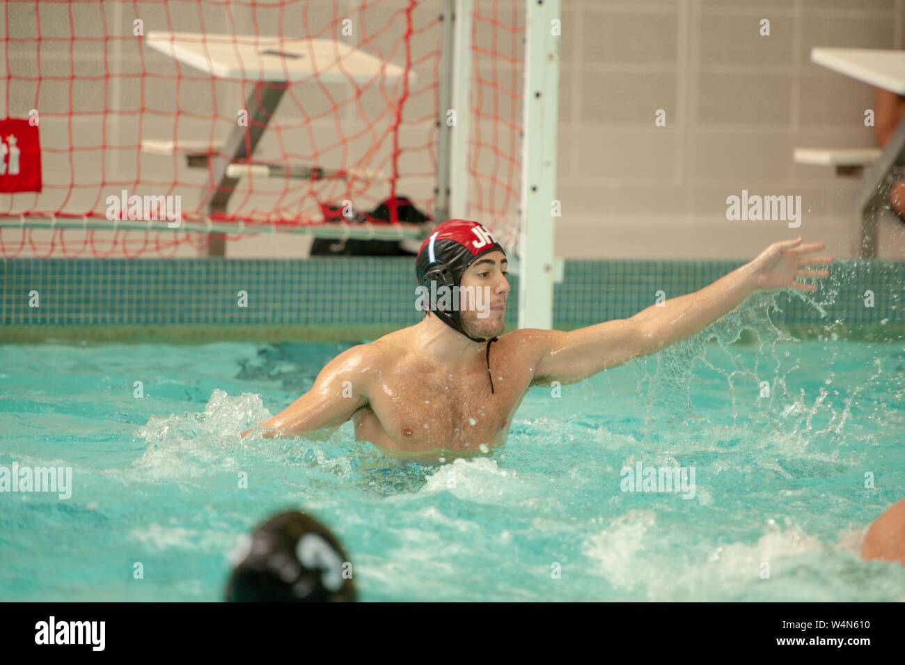 A Johns Hopkins Blue Jays Men's Water Polo player reaches forward with one arm while participating in a game with Princeton University, September 25, 2010. From the Homewood Photography Collection. () Stock Photo