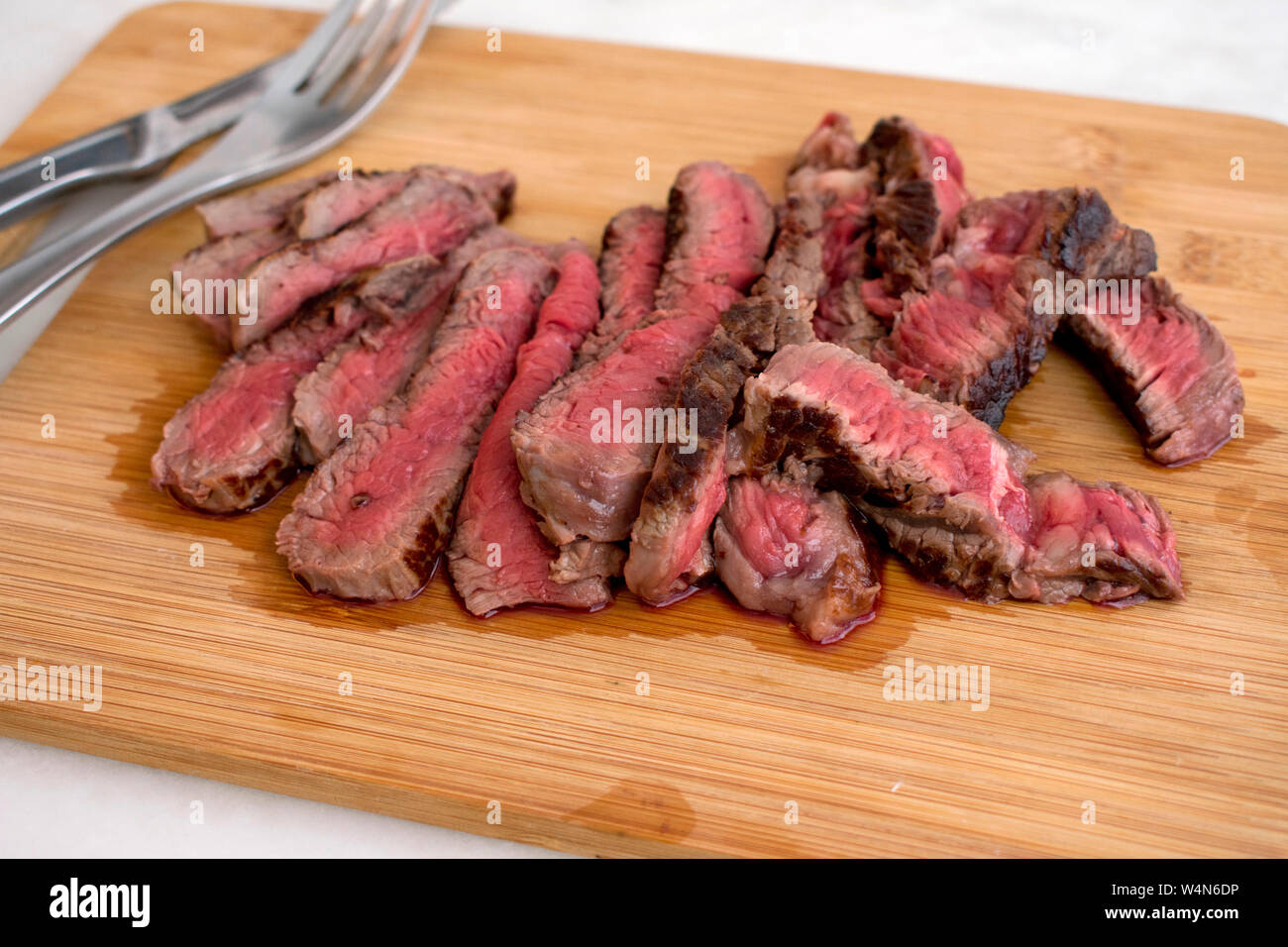 Sliced Rare Steak on a Cutting Board Stock Photo