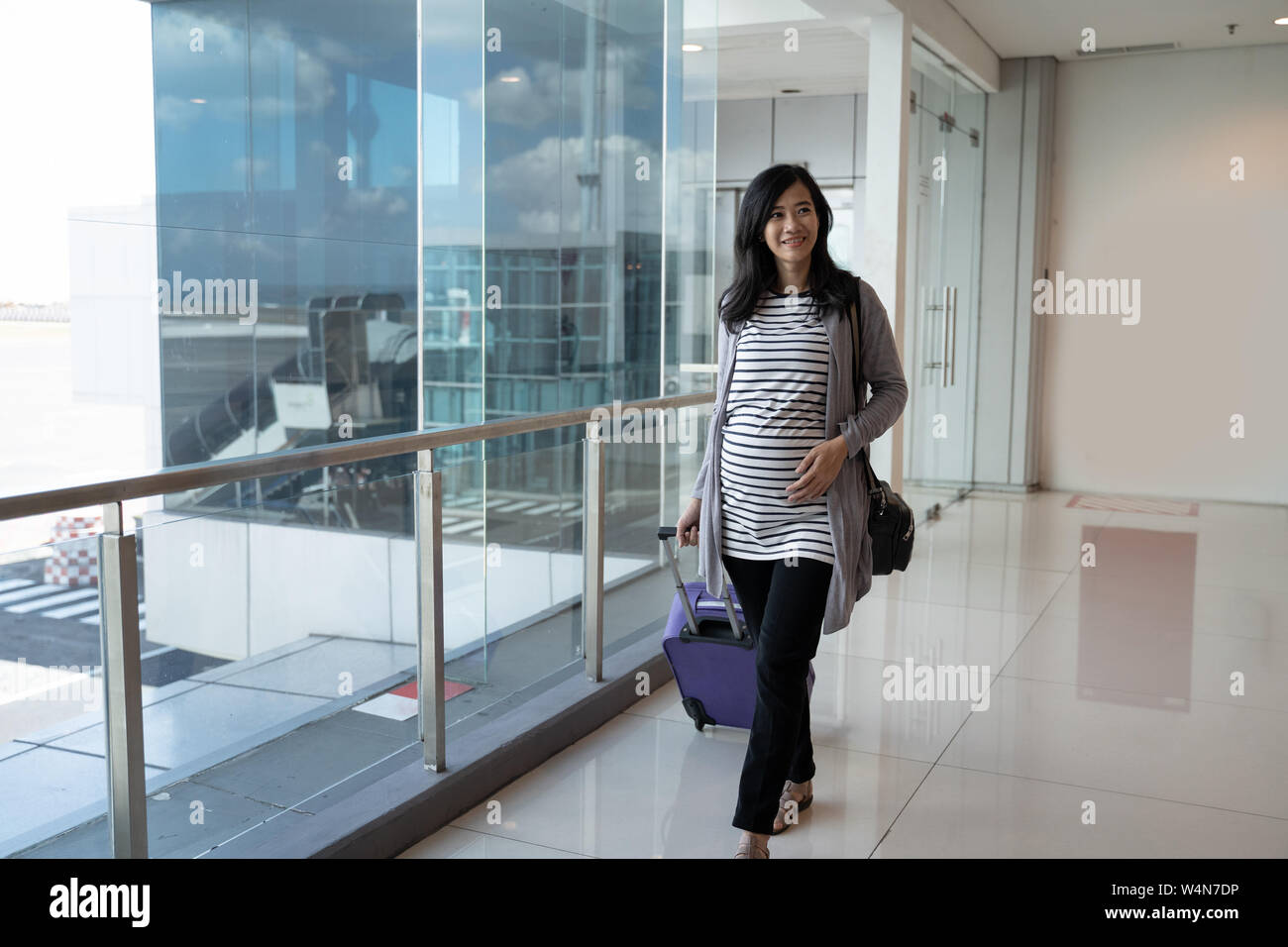 a pregnant mother stands holding her stomach Stock Photo - Alamy