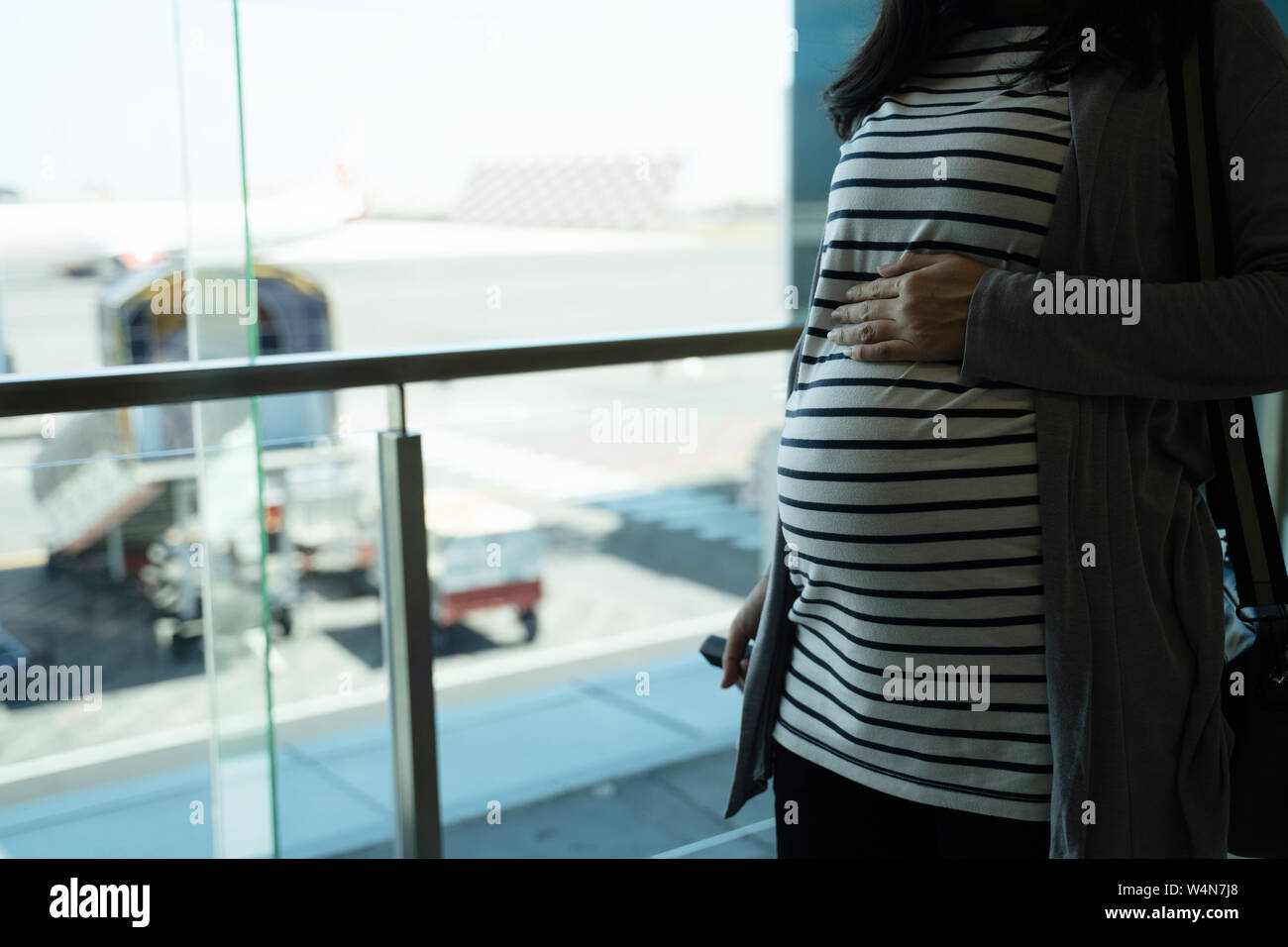 a pregnant mother stands holding her stomach Stock Photo - Alamy