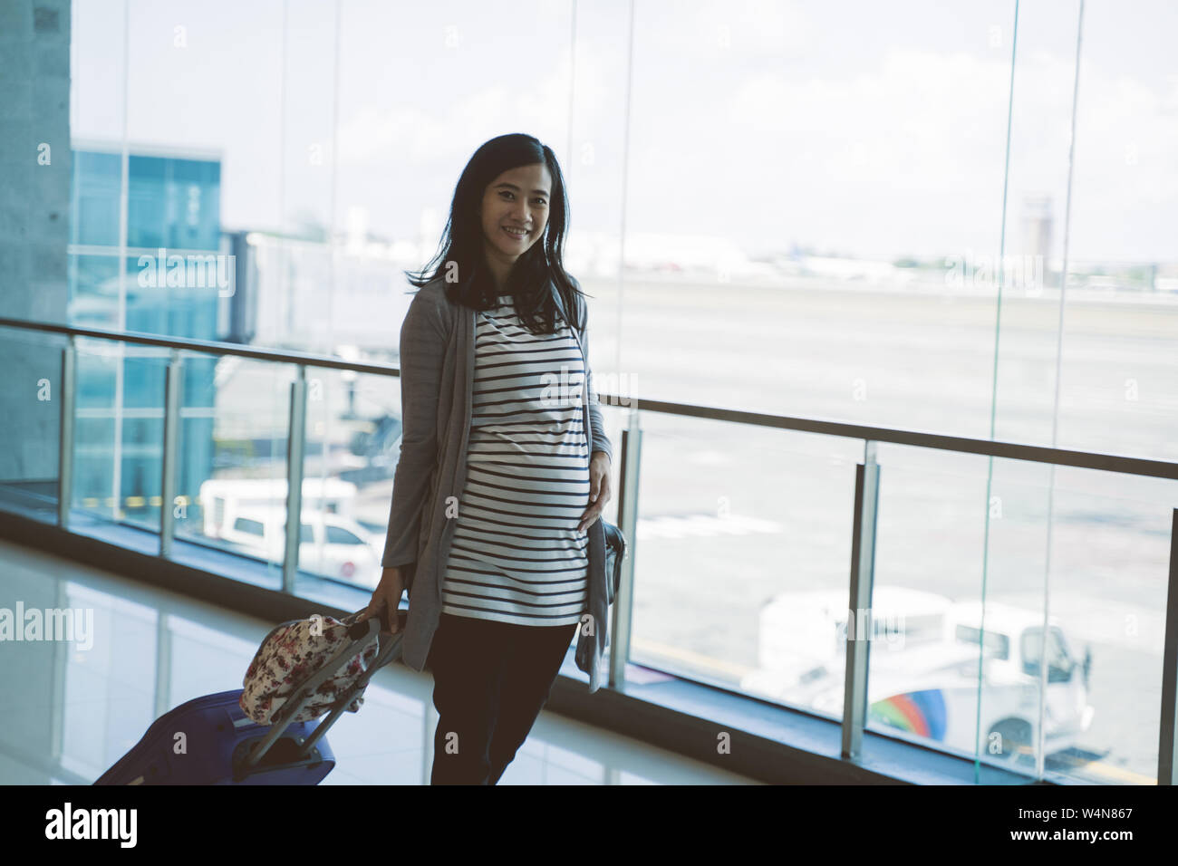 a pregnant mother stands holding her stomach Stock Photo - Alamy